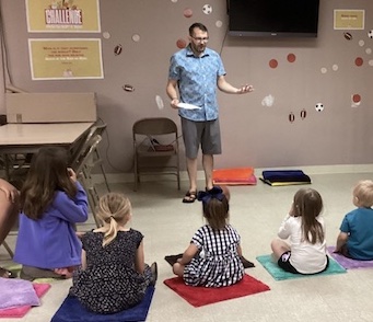 Next Gen Kids Sunday School Class with Pastor Tyrel LaValle standing in front of the class as they sit on matts.